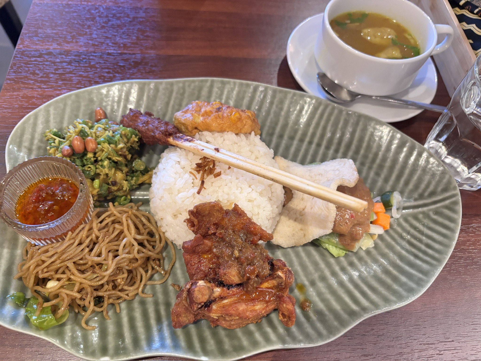 「ナシチャンプル：インドネシアの定番ワンプレート。サンバルや揚げ物、野菜炒めなどがご飯と共に盛り付けられている。」