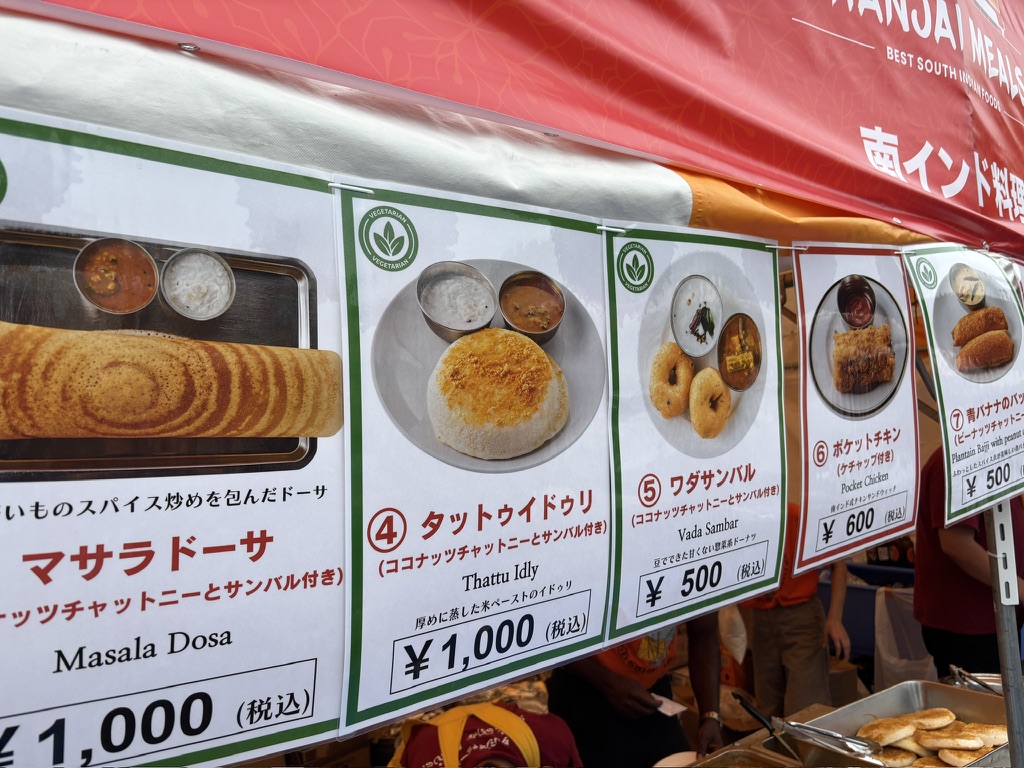 マサラドーサ、タットゥイドゥリ、ワダなど南インド料理の写真付きメニューが並ぶ屋台。価格も明示されている。