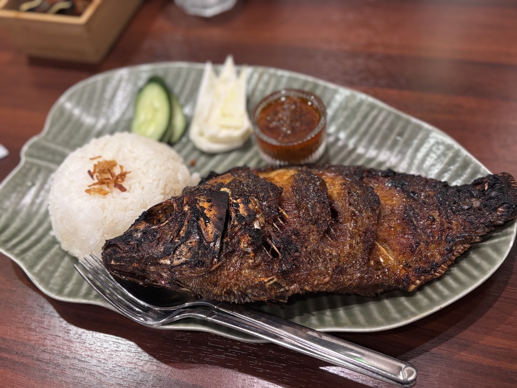 「インドネシア料理イカンバカール。丸ごとのティラピアを甘辛ソースで焼き上げたグリル」