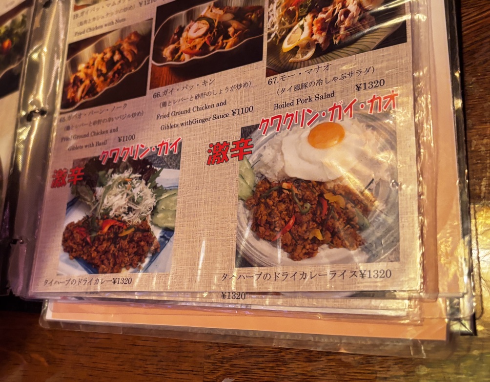 「中目黒Soi7のメニューより、激辛表記のタイ南部料理『クワクリン・ガイ』と『クワクリン・ガイ・カオ』。パリッとした目玉焼きをのせたドライカレーライスと、香草たっぷりの単品盛りが並ぶ。」