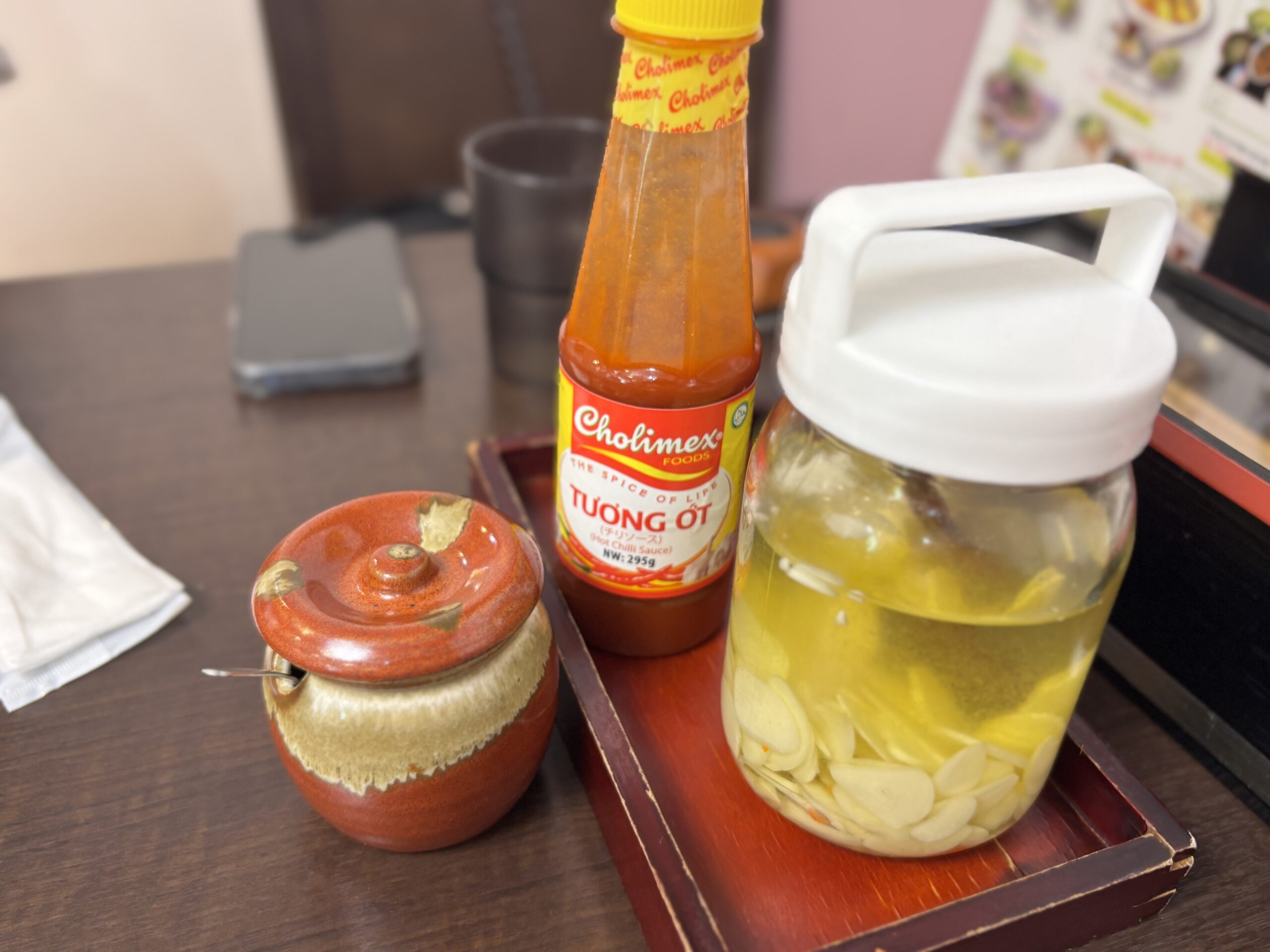 「卓上のベトナム調味料セット。チリソース、にんにく酢漬け、唐辛子入りペースト。」