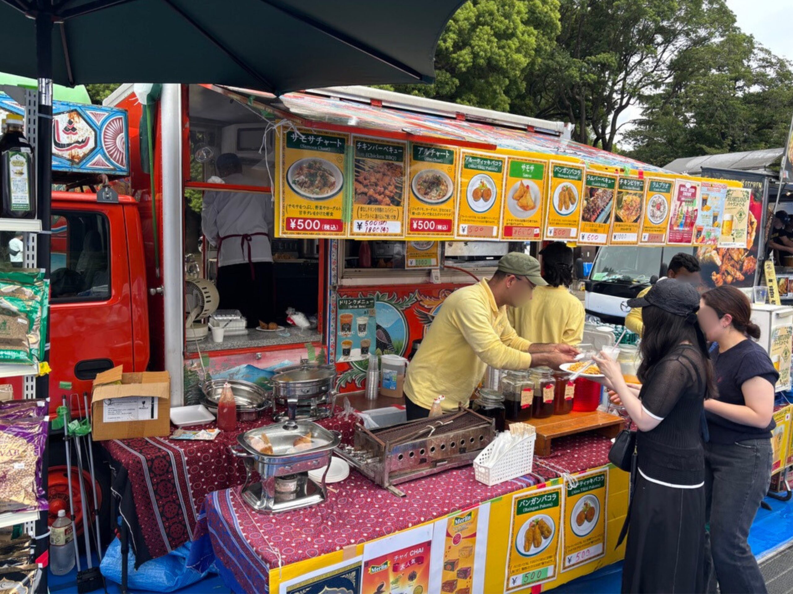 サモサやチキンバルチを販売する赤いキッチンカー
Red food truck selling Samosa and Chicken Balti.

