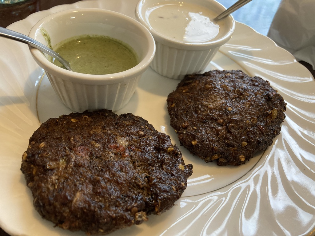 香ばしく焼き上げられた丸形のチャプリカバーブ2枚と、ミントソース・ヨーグルトソースが添えられた一皿。@メヘマンサラエ野田