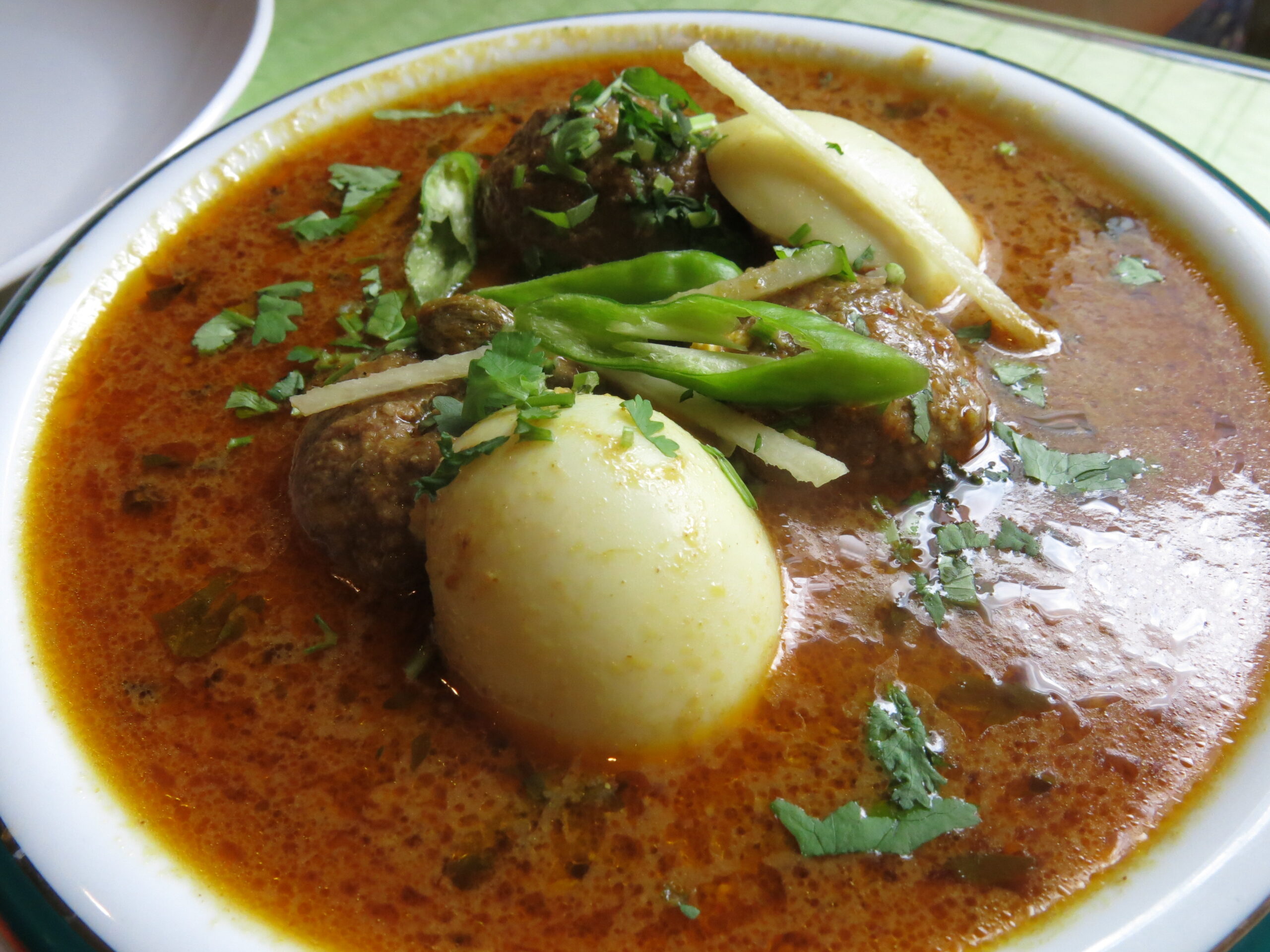 ゆで卵を肉団子で包み、スパイス香るカレーソースで煮込んだナルギシコフタ。断面が春咲きの水仙の花のように見える豪華な一皿。