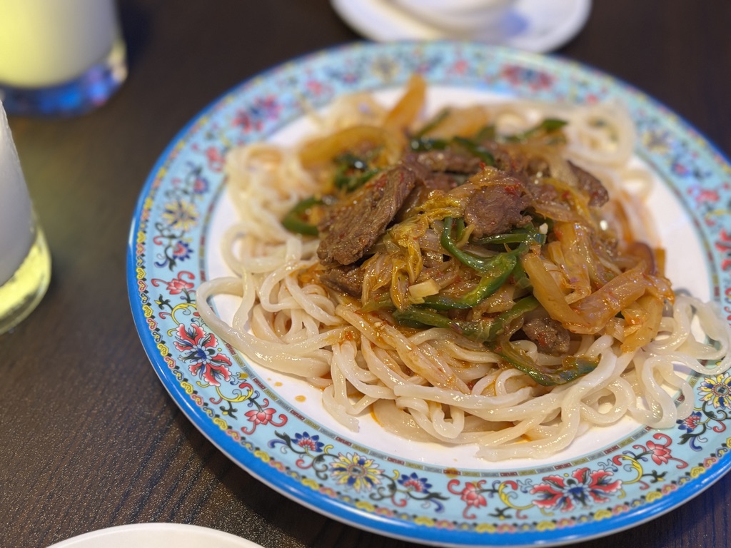 ウイグル風ラグメン。手打ち風の太麺に、ピーマンや玉ねぎ、牛肉のスパイシーな炒めがたっぷりかかった一皿