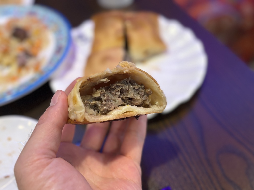 ウイグル料理「サムサ」の断面。牛ひき肉と玉ねぎのジューシーな餡がぎっしり詰まった肉パイの断面ショット