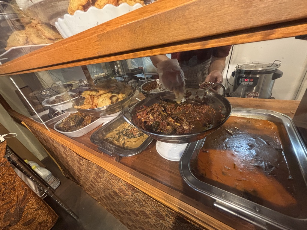 MONGGO MOROでインドネシア惣菜を取り分ける様子（新宿三丁目・ワルン形式）