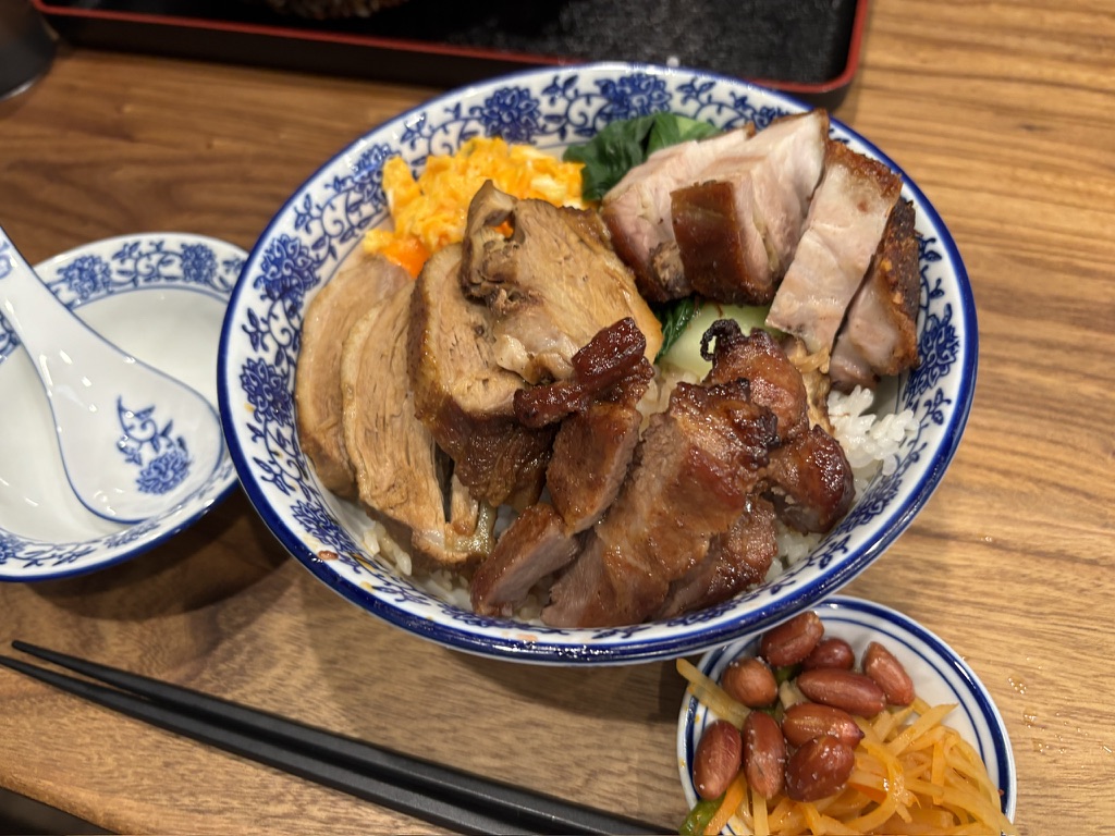 三拼飯の全景。大きめ丼に叉焼・豚バラ・チャーシューが盛られ、添え物の紅生姜と落花生。