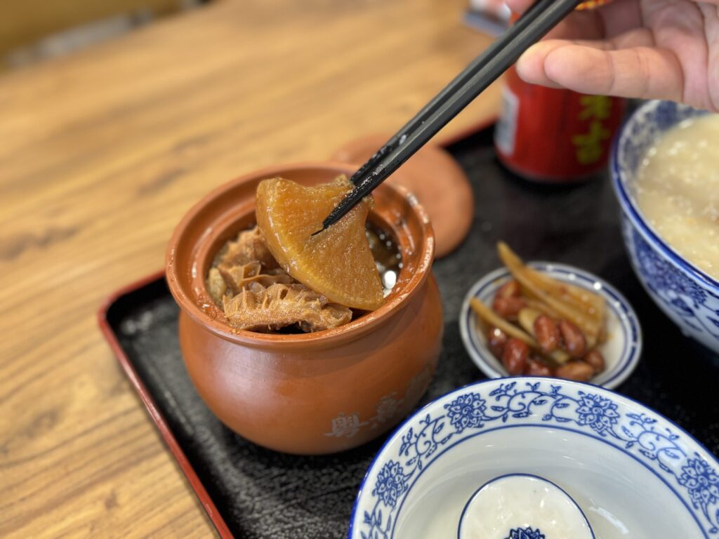 牛雑煲の具材を箸でつまむ。大根と蜂の巣トライプ。