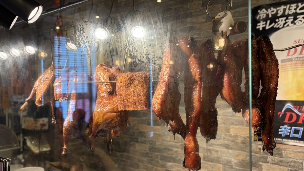 粤鼎の店頭ショーケースに吊るされた広東の燒臘(ローストガチョウ・焼き豚)