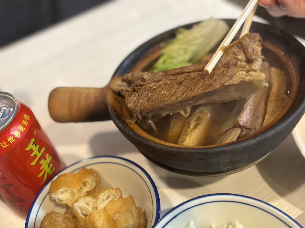 箸で持ち上げたスペアリブ肉骨茶の骨付き肉