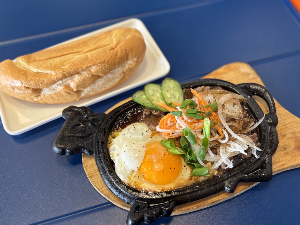 NaNa Cafe名物のボーネー 牛型の鉄板にのった目玉焼きと牛肉、バゲット添え